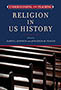 Understanding and Teaching Religion in US History: cover depicting a close up photograph of wooden benches, like you might find in a house of religious worship. The title text is contained within a blue box at the top of the page.